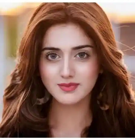 Woman with long brown hair and red lipstick against a blurred background (Verified reviewer)